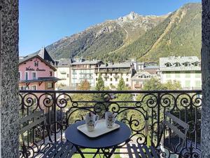 una mesa en un balcón con vistas a la ciudad en Appartement Chamonix-Mont-Blanc, 4 pièces, 8 personnes - FR-1-507-25, en Chamonix-Mont-Blanc