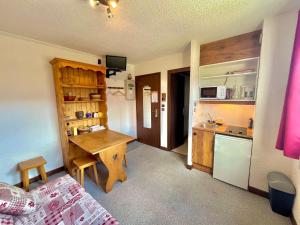 a room with a kitchen with a table and a bed at Studio Notre-Dame-de-Bellecombe, 1 pièce, 2 personnes - FR-1-505-48 in Notre-Dame-de-Bellecombe