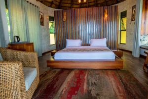 a bedroom with a bed and a couch and a chair at Sundiata Beach Resort 