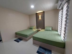 um quarto com duas camas e uma janela em ริมธารริเวอร์เพลส em Surat Thani