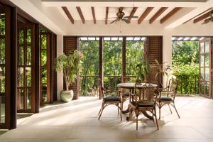 a conservatory with a table and chairs on a patio at The Red Hen Homestead in Batangas City