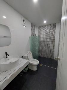 uma casa de banho com um lavatório, um WC e um chuveiro em ริมธารริเวอร์เพลส em Surat Thani