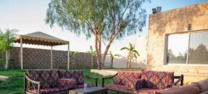 een patio met banken en een tafel in de tuin bij استراحه القاعد in At Turbīyah