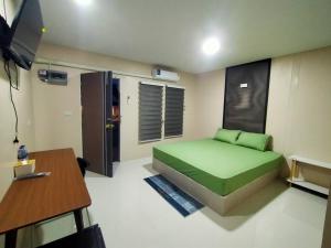 a bedroom with a green bed and a table at ริมธารริเวอร์เพลส in Suratthani