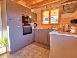 a kitchen with stainless steel appliances and wooden ceilings at Chalet typique, 4 chambres, vue montagne, WIFI, parking - FR-1-505-66 in Notre-Dame-de-Bellecombe +11 photos