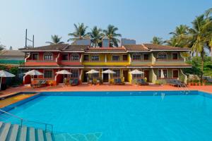 a large house with a swimming pool in front of it at Skylark Resort in Colva