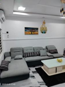 een woonkamer met een bank en een tafel bij UCLAS Gorgeous Apartment in Port Harcourt