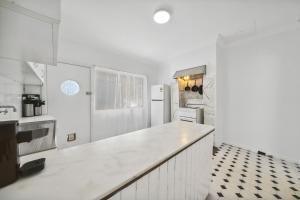 a white kitchen with a counter and a refrigerator at Freelander Retreat in Katoomba