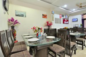 a dining room with tables and chairs and flowers at Hotel Nature View near Mall Road in Dharamshala
