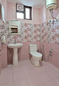 a pink bathroom with a toilet and a sink at Hotel Nature View near Mall Road in Dharamshala
