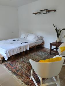 1 dormitorio con 1 cama y 1 silla blanca en Hermoso Palomino, en Palomino