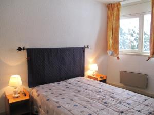 a bedroom with a bed with two lamps and a window at Appartement Villard-de-Lans, 2 pièces, 6 personnes - FR-1-515-29 in Villard-de-Lans