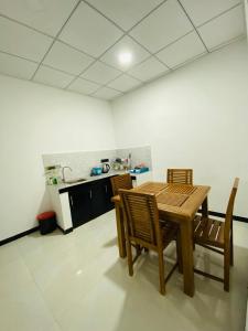cocina con mesa de madera y sillas en una habitación en Minuki guest house, en Weligama