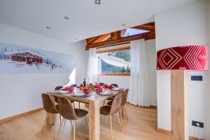 een eetkamer met een houten tafel en stoelen bij Chalet Merveille Ski In - Ski Out - Happy Rentals in Sauze dʼOulx
