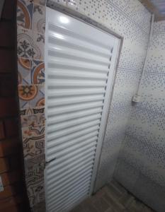 B & B Hostel Ingleses في فلوريانوبوليس: باب أبيض في حمام به جدار