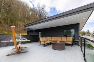 a backyard patio with a couch and a table at Mountain Retreat with Views, Hot Tub, Games & AC in Chilliwack