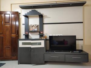 a living room with a flat screen tv and a tv stand at UDUPI G01 HOMESTAY in Udupi