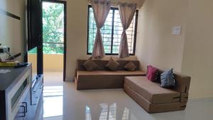 a living room with a couch and a window at UDUPI G01 HOMESTAY in Udupi