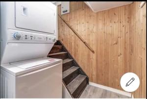 a small laundry room with a washer and a staircase at Cozy room at walkout basement in Pickering