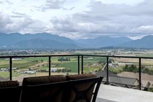 a balcony with a view of a city and mountains at A Mountain Retreat with Views, Hot Tub & AC in Chilliwack