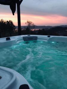 a jacuzzi tub with a sunset in the background at Happy House Bungalov Three-Room SPA JAKUZİ Lake view in Sapanca B2 in Sapanca