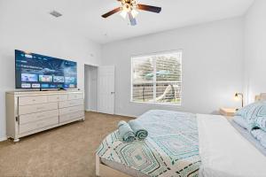 a bedroom with a bed and a flat screen tv at 4 BR w/ Pool 10 min to Six flags, AT&T Stadium & Glode Life Park in Grand Prairie