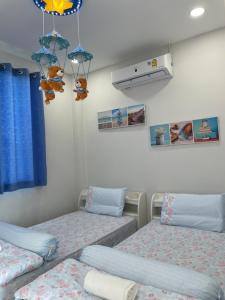 um quarto com 2 camas individuais e um aquecedor em Baan pakiet&Khun jang em Ban Nam Lai Ta Tum