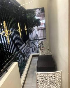 a balcony with a bench and a black fence at Mayura home in Pondicherry