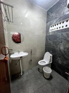 a small bathroom with a sink and a toilet at Mayura home in Pondicherry