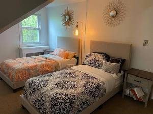 a bedroom with two beds and a window at BBQ, Beats, Hot Tub Retreat in Baldwin