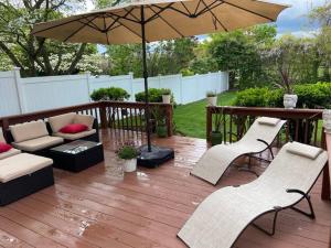 a patio with an umbrella and chairs and a table at BBQ, Beats, Hot Tub Retreat in Baldwin