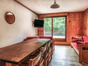 ein Wohnzimmer mit einem Holztisch und einem TV in der Unterkunft Appartement Val-d'Isère, 5 pièces, 8 personnes - FR-1-519-20 in Val dʼIsère