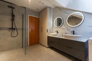a bathroom with two sinks and two mirrors at Sarajevo Central Elegance Apartments in Sarajevo