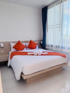 a bedroom with a large bed with red pillows at White Seaview Residence in Klong Muang Beach