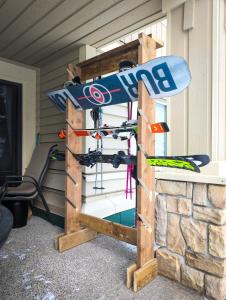 a wooden rack with skis and snowboards on it at 2 Bedroom and Wall Bed Mountain Getaway Ski In Ski Out Condo with Hot Pools Sleeps 8 in Panorama