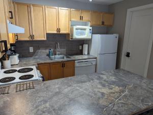 a kitchen with a white refrigerator and a sink at 2 Bedroom and Wall Bed Mountain Getaway Ski In Ski Out Condo with Hot Pools Sleeps 8 in Panorama