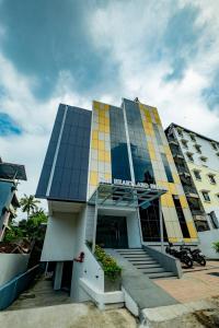 un hotel con un edificio amarillo y azul en The HEARTLAND Hotel en Thiruvananthapuram