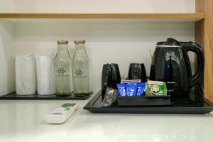 a shelf with three glass bottles and a coffee maker at The HEARTLAND Hotel in Trivandrum