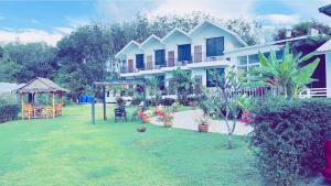 una casa con un patio con plantas y un cenador en White Seaview Residence, en Klong Muang Beach