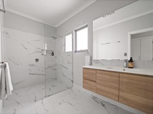 a white bathroom with a shower and a sink at Park View in Margaret River Town +21 photos