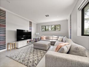 a living room with two couches and a flat screen tv at Park View in Margaret River Town
