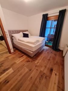 ein weißes Sofa in einem Zimmer mit Holzboden in der Unterkunft Best place Apartment "Ambiente" include Jokercard in Saalbach-Hinterglemm