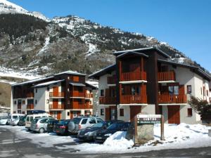 a parking lot with cars parked in front of a building at Appartement pour 4 personnes à Val Cenis Lanslevillard, proche remontées mécaniques et commerces - FR-1-508-231 in Lanslebourg-Mont-Cenis