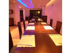 a long row of tables in a room with purple lights at O'sinkirri in Nairobi