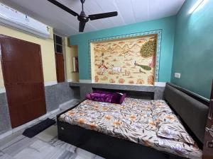 1 dormitorio con 1 cama con una pintura en la pared en MOON NIGHT GUEST HOUSE, en Jodhpur