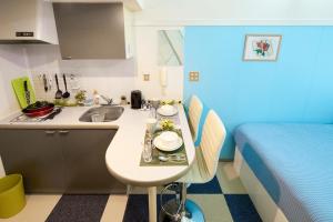 eine kleine Küche mit einem Waschbecken und einem Bett in der Unterkunft SC Heights 103 in Tokio