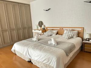 una camera da letto con un grande letto con lenzuola e cuscini bianchi di Roomy 4BR Home Sleeps 9／ShinOsaka／Large Groups ad Osaka