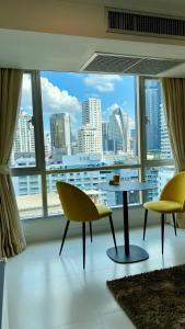 a room with a table and chairs and a large window at Sukhumvit13 Luxury suite in Bangkok