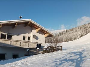 a building on a snowy hill with a snow covered yard at Holiday home Hart im Zillertal in Hart im Zillertal