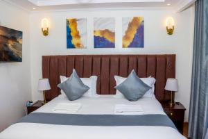 Schlafzimmer mit einem Bett mit blauen und weißen Kissen in der Unterkunft Sangara by Edmor Suites in Nairobi